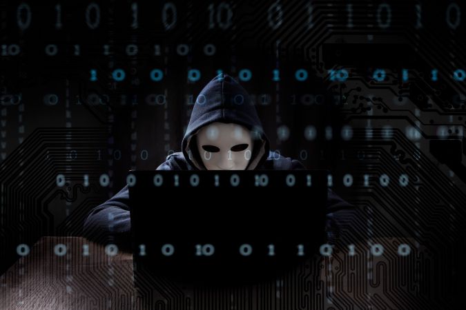 Hacker enmascarado usando una computadora