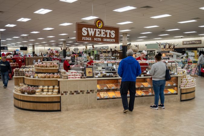 Dos personas en el puesto de dulces en Buc-ee's.