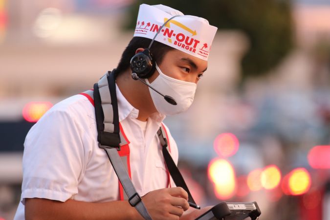 Empleado de IN-N-OUT BURGER tomando una orden.