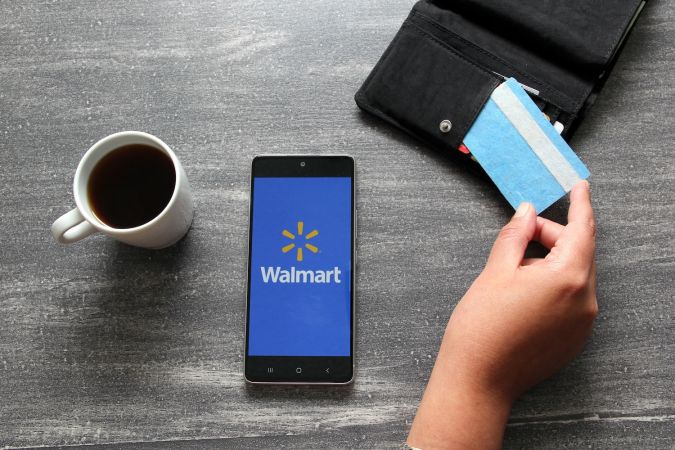 Aplicación de Walmart en teléfono inteligente junto con tarjeta de crédito.