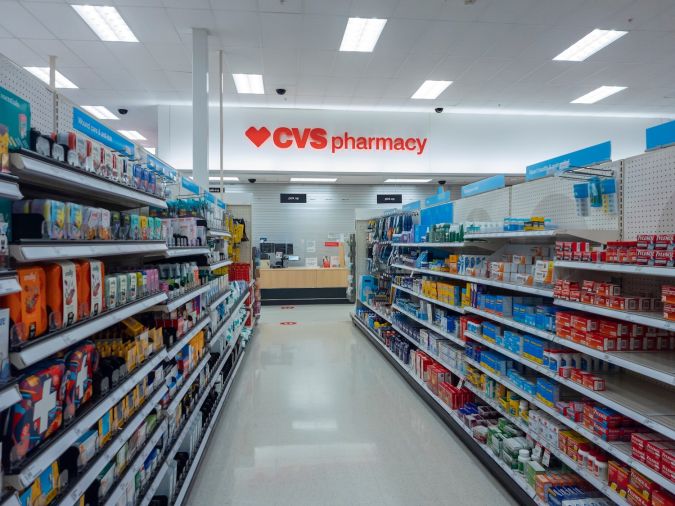 Vista del interior del edificio de la farmacia CVS con pasillos de medicamentos en primer plano.