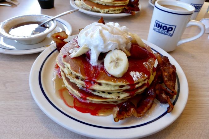 Panqueques IHOP con tocino, jarabe de arce y plátano y crema.