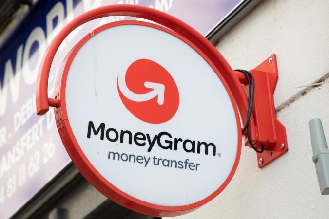 Texto y logotipo del letrero de transferencia de dinero de la marca MoneyGram, fachada de la entrada.