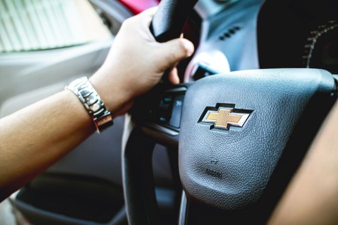 Fotografía de un hombre dentro de un automóvil Chevrolet Agile modelo 2014, sosteniendo el volante.