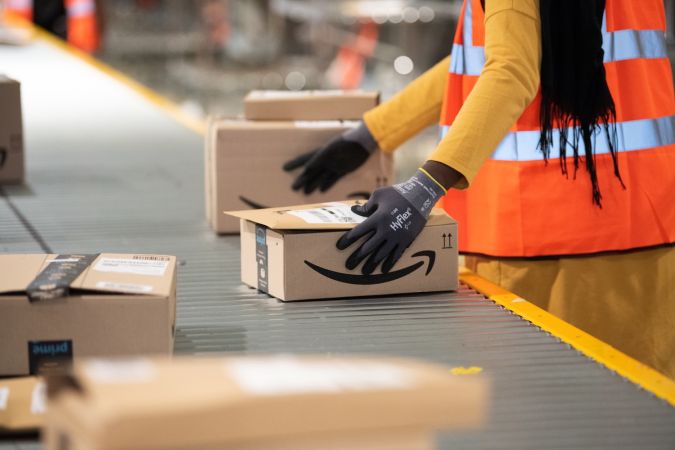 Empleados de Amazon clasificando paquetes.